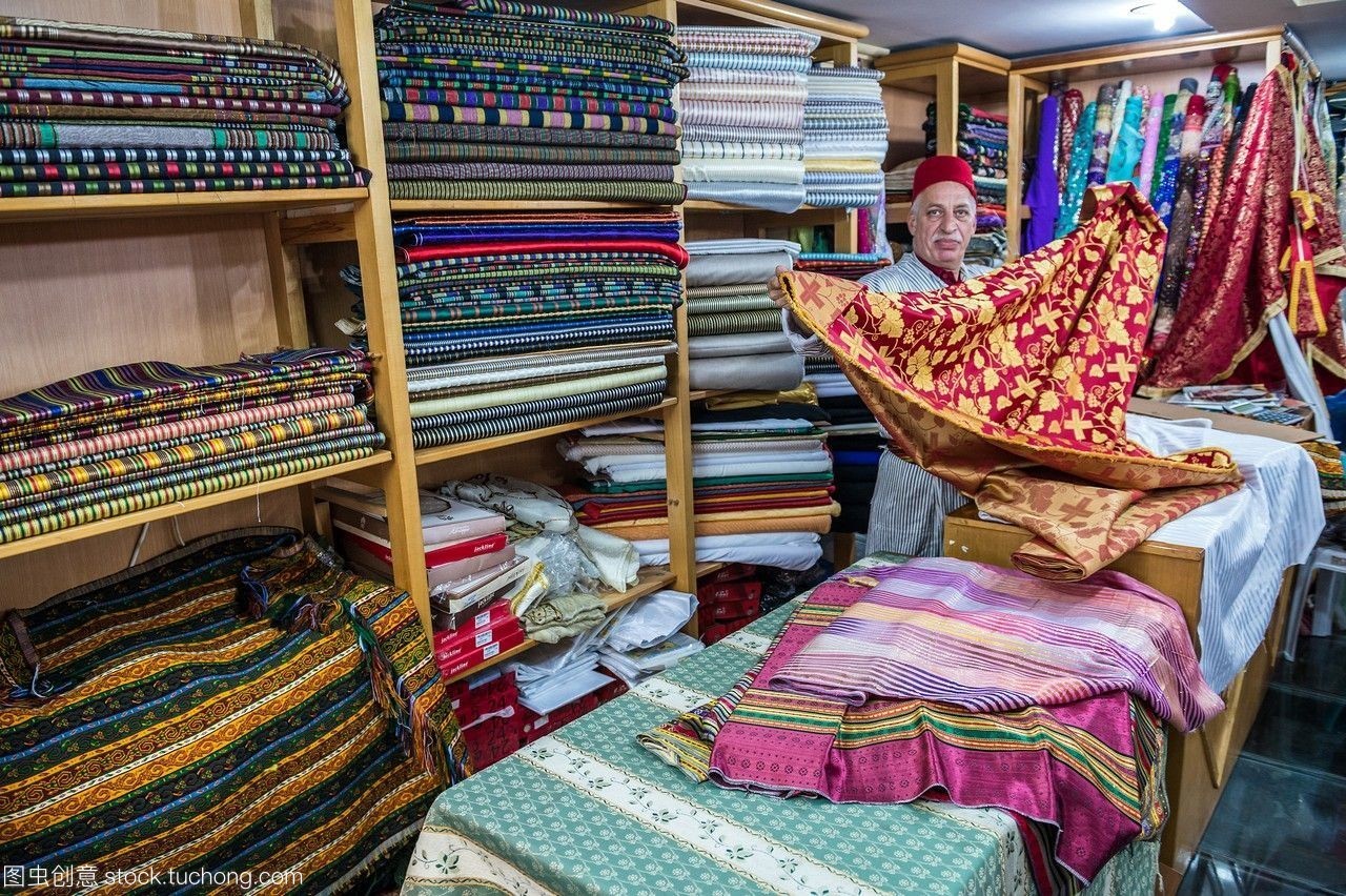 進(jìn)口東方紡織品的經(jīng)銷商bilalabukhalaf在以色列耶路撒冷老城的一個市場上展示了紡織品。